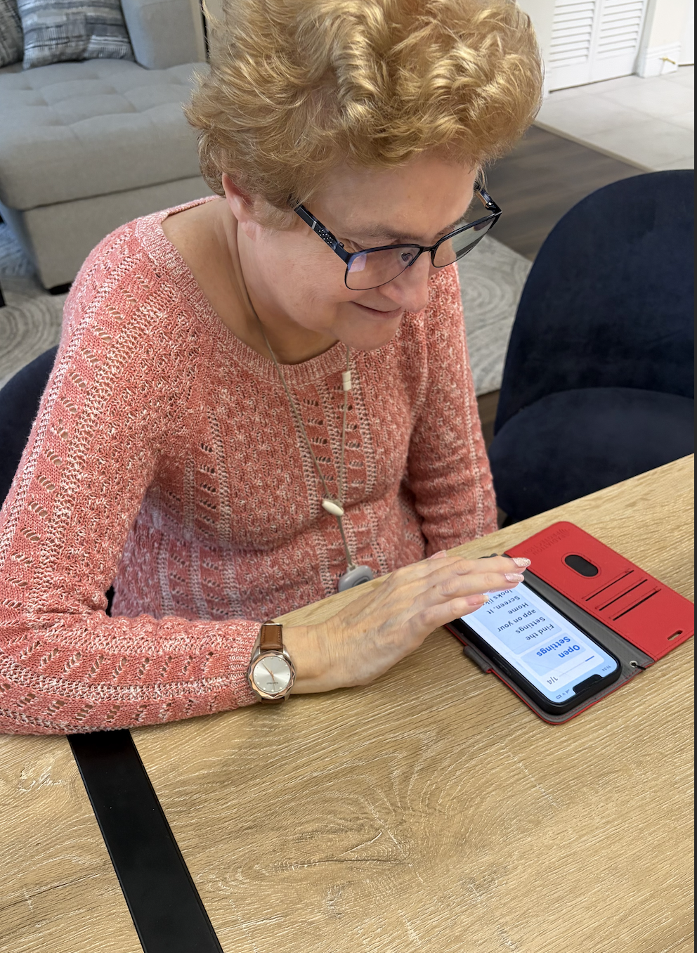 Senior reading Pebl instructions on a phone